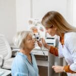 A woman undergoing an eye examination with an ophthalmologist, focusing on measuring her eye pressure.